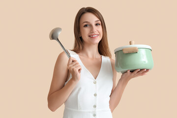 Poster - Young woman with cooking pot of chicken soup and ladle on beige background