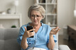 © fizkes - Annoyed frustrated mature retired woman in glasses getting problems with smartphone, trouble with online connection, communication, reading bad news, using mobile phone