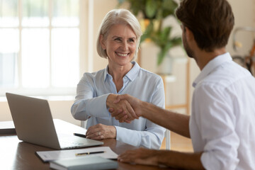 Canvas Print - Aged businesswoman handshake greets company client, shaking hands sign of respect, hope for future cooperation, succeed result effective negotiations ending, making deal, hr got job employment concept