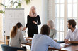 © fizkes - Middle eastern ethnicity coach in hijab islamic traditional wear make presentation on flip chart offer solution express opinion, explain data financial forecasting to staff, corporate training concept