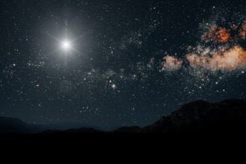 A christmas star shines at night over the mountains of Bethlehem