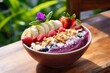Leinwandbild Motiv trendy delicious sweet fruit smoothie acai bowl with berries, seeds, nuts and granola on a cafe table at the seaside or ocean in Bali, sunny summer weather