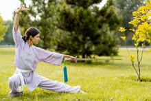Martial Arts Woman Practicing Wushu Kung-fu With Sword At Green Park