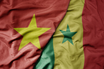 big waving realistic national colorful flag of vietnam and national flag of senegal .