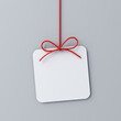 Hanging minimal gift box rounded square sign paper card with red ribbon rope bow isolated on grey background with shadow minimal conceptual 3D rendering