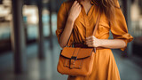 Fototapeta  - Close up of Stylish fashionable woman wearing bright dress holding brown bag handbag. Generative Ai