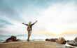 © Davide Angelini - Happy man with backpack standing with arms up at the beach - Delightful tourist enjoying summer vacation by the seaside - Traveling life style and well being concept