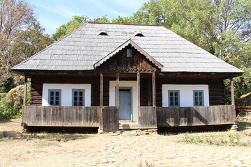 Wall Mural - A house with a porch and a tree in the background