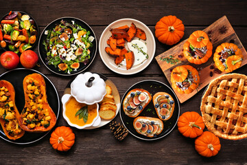 Aufkleber - Delicious autumn meal table scene. Top view on a dark wood background. Stuffed pumpkins and squash, sweet potatoes, appetizers, soup, vegetables and apple pie.