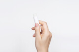 Fototapeta  - female hand holding hygienic lip balm on a white background