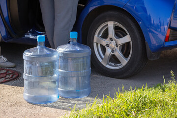 
Two empty water cans are placed next to the car