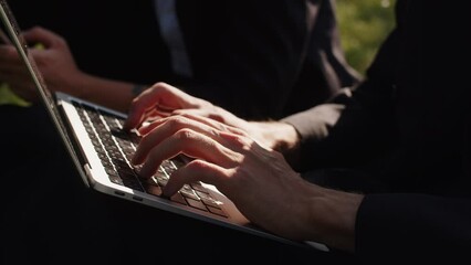 Cropped video illustration of fast speed typing hands coding notebook modern wireless technology outdoor working. Business workers using laptop.