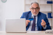 © Elnur - Old male employee holding credit card