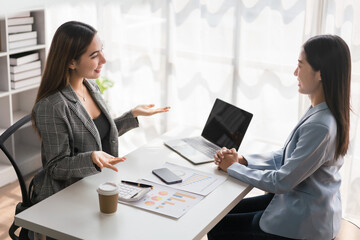 Businesswoman working on laptop to explaining project of business and finance document to partner