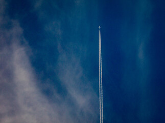 Wall Mural - Airplane at high altitude flying in cirrus clouds against a bliue sky