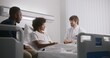 © Framestock - Physician reports test results to clients using tablet computer. African American boy and his father consults with doctor. Patient recovering after surgery. Medical personnel work in hospital ward.