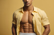 © Athena  - close-up view of six pack abs in studio, pastel yellow background