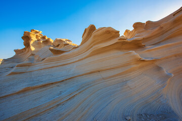 Wall Mural - Desert eroded rock pattern with clear sky. Desert rock formation with erosion