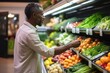 © Stavros - Mature African American man shopping in grocery store. Side view choosing fresh fruits and vegetables in supermarket. Shopping concept.