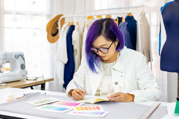 Wall Mural - Fashionable freelance dressmaker is designing on new dress by drawing illustrator while working in artistic workshop studio for fashion design and clothing business industry concept