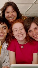 Wall Mural - Group of multiracial college students smiling at camera while standing together working on laptop. Youth community and young people concept. Vertical 9:16 screen video. 