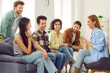 © Studio Romantic - Group of young people hanging out at home. Friends gather at someone's place and have fun together. Happy men and women sitting on couch, talking about college life, sharing stories and telling jokes