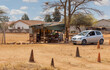african township a driving school operating in front of the shack of a street vendor on a dirt road in the city