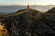 Punta Robaleira red lighthouse in Home cape at sunset in Rias Baixas zone in Galicia coast with Cíes islands in the background.