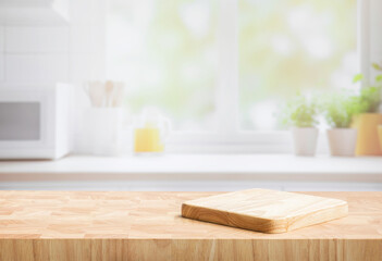 Wall Mural - Selective focus.End grain wood counter top with cutting board on blur kitchen in morning window background