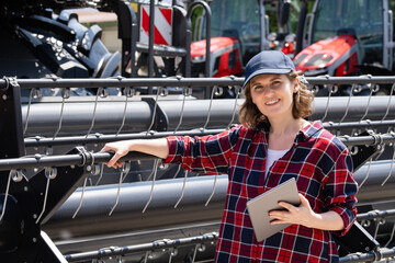 Aufkleber - Woman farmer with digital tablet on a background of harvester. Smart farming concept