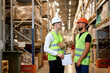 © alfa27 - warehouse managers in work wear organizing distribution in warehouse storage area. Caucasian men in green uniform discuss product delivery, having talk. in retail Warehouse full of Shelves with Goods