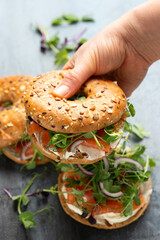 Wall Mural - Smoked salmon and soft cheese seeded bagel with pea and purple reddish shoot salad and red onion. Protein packed breakfast concept