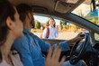 © Prostock-studio - Happy parents bringing their daughter to school, sitting in car and waving hands to child girl