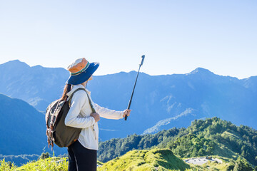 Poster - Girl on mountain peak use of 360 camera to take photo on mountain valley