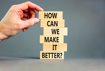 We make it better symbol. Concept words How can we make it better on wooden block. Beautiful grey table grey background. Businessman hand. Business we make it better concept. Copy space.