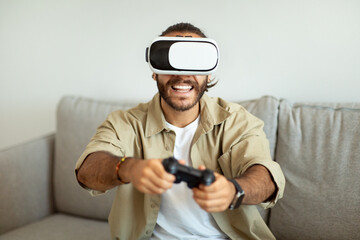 Wall Mural - Happy young man playing video games at home, using VR