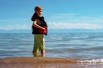 Poster - Boy in vest and shorts turned around, standing in the water