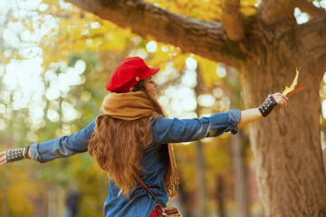 Wall Mural - happy trendy woman in jeans shirt and red hat rejoicing