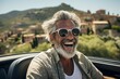 Gray-haired elderly man in cabriolet enjoying a ride. Portrait with selective focus and copy space