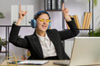 Happy relaxed overjoyed Caucasian business woman working on laptop computer at office wearing headphones listening favorite energetic disco music and dancing. Freelancer girl relaxing, taking a break