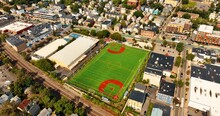 View Of Green Football Pitch In The City Neighborhood. Sunny Panorama Of Cambridge, Massachusetts, USA From Top Perspective.