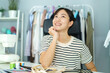 © DG PhotoStock - Happy beautiful Asian young woman working in the fashion design studio, professional female fashion designer portrait in design studio.