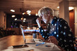 © Marko Geber - Middle aged caucasian woman going over her bills and home finances at night while using her laptop