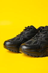 Wall Mural - Black new sport sneakers on yellow background