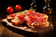 Toast with tomatoes and slices of jamon serrano ham