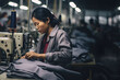 Portrait of asian woman sewing clothing in Multinacional Factory , precarious jobs, poor work condition, exploitation and fast fashion concept