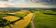  Aerial Shot of Rural Farmland . Aerial rural landscape with yellow patched agriculture fields and blue sky with white clouds .