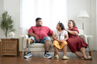 © Wosunan - A plus size family with a father wearing a prosthetic leg, Resting and talking with daughter on the weekly holiday, in the living room of the house.