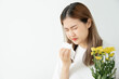 Pollen Allergies, asian young woman sneezing in a handkerchief or blowing in a wipe, allergic to wild spring flowers or blossoms during spring. allergic reaction, respiratory system problems