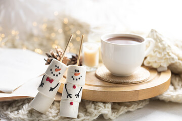 Wall Mural - Winter composition with a cup of cocoa and marshmallows on a blurred background.